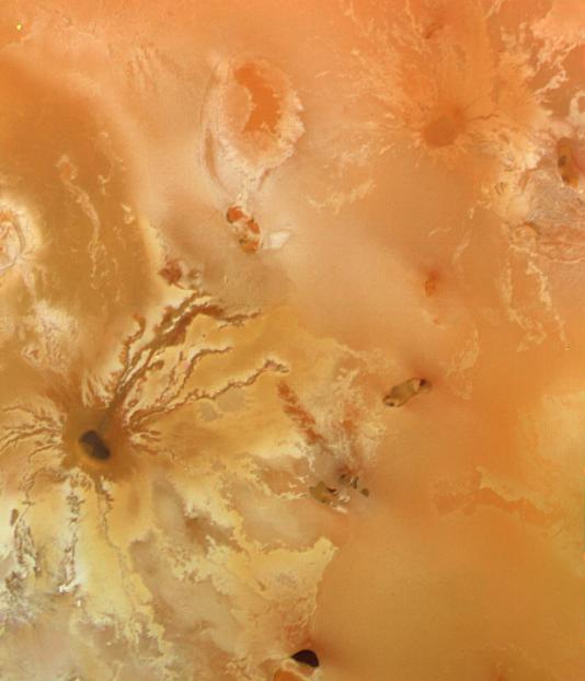 This color picture of Jupiter's moon Io was taken by Voyager 1 in 1979 at a range of 77,100 miles. The dark spot with the irregular radiating pattern near the bottom of the photo may be a volcanic crater with radiating lava flows.