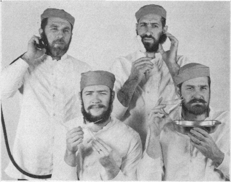 Four white bearded men in lab coats.