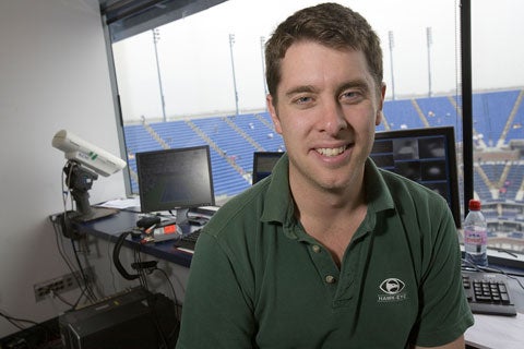 Hawk-Eye inventor Paul Hawkins sits in front of three of the seven computer screens and one of the Hawk-Eye high-speed cameras perched over Arthur Ashe Stadium. Implementation of the first truly instantaneous instant-replay system in sports will cost the USTA approximately $300,000 this year.