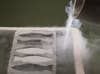 A person pouring liquid nitrogen onto mercury inside fish molds.