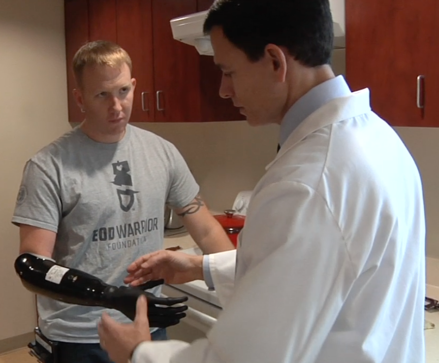 SSgt. James Sides, left, talks with Dr. Paul Pasquina, principal investigator on a new implantable device that can control a prosthetic limb with an amputee's own muscle.