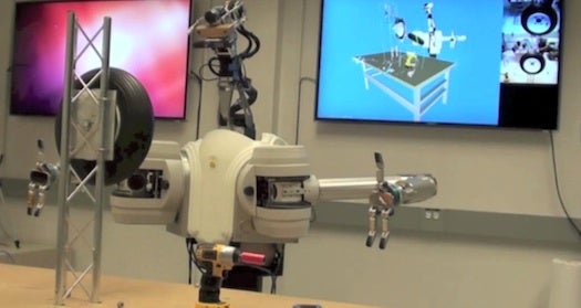 A screenshot from a Defense Advanced Research Projects Agency video of its tire-changing robot