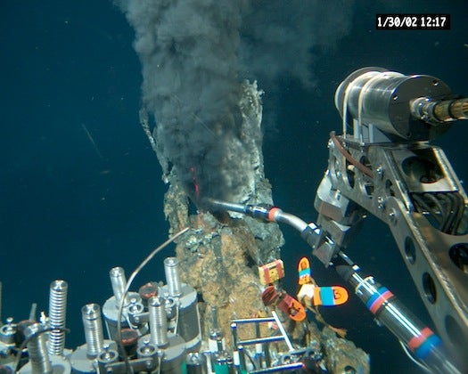 <em>Alvin</em> collects samples from a black smoker hydrothermal vent along the East Pacific Rise, a boundary under the Pacific Ocean where two tectonic plates diverge. The billowing cloud is not actually smoke, but scalding water, rich in iron and sulfur, meeting chilly water. Despite their scalding hot temperatures, hydrothermal vents are home to some of the hardiest bacteria ever discovered.