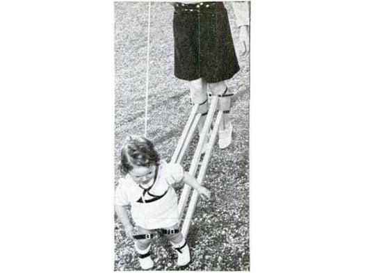 To teach his young son to walk, a Swiss engineer built the curious apparatus shown above. Pairs of wooden arms are strapped at one end to the infant's legs and at the other to the legs of an adult, so that the latter can control the baby's leg movements. A harness connected to a pulley on an overhead wire holds the child upright while it is taking its first steps.