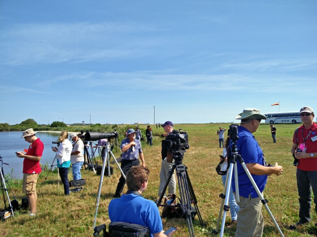 reporters setting up cameras in a field