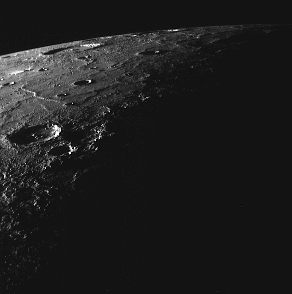 As <em>Messenger</em> was nearing its closest approach to Mercury, one of its cameras captured this image of the northernmost region of Mercury's surface illuminated by sunlight. The brightly lit northeastern walls of large impact craters can be seen near the horizon. The Sun's angle also accentuates wrinkle ridges winding across the smooth plains. In the foreground, the terminator separates day from night.