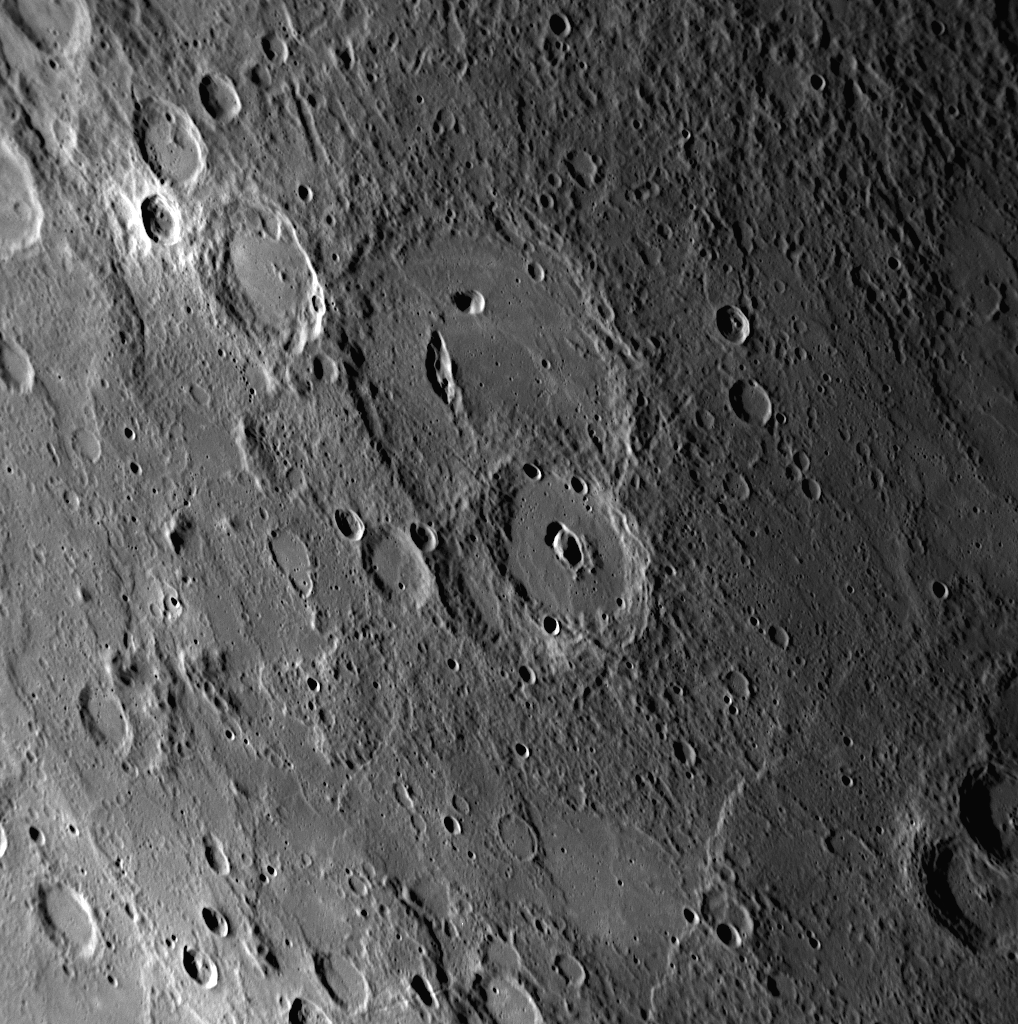 Craters on Mercury with non-circular, irregularly shaped depressions or pits on their floors have been termed pit-floor craters. The pits could be evidence of volcanic processes. This image shows a good view of a pit-floor crater. The large crater near the center of the image contains an elongated bean-shaped depression on its floor and is a pit-floor crater. The slightly smaller crater to the south also contains a pair of depressions on its floor, though it is unclear from this image if the depressions are pits or overlapping impact craters.