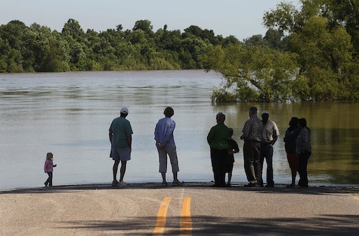 KROTZ SPRINGS, LA - MAY 15: People look on at the flooded at the flooded Atchafalaya River during a mandatory evacuation on May 15, 2011 in Krotz Springs, Louisiana. The Morganza Spillway floodgates were opened for the first time in nearly forty years yesterday to lower the crest of the flooding Mississippi River. St. Landry Parish officials ordered a mandatory evacuation today for around 2000 residents in Krotz Springs and nearby Melville, Louisiana. (Photo by Mario Tama/Getty Images)