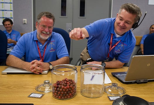On the day of the rover's landing, NASA scientists move the final marble from a jar marked "Days Until Entry" to another jar marked "Days Since Launch."