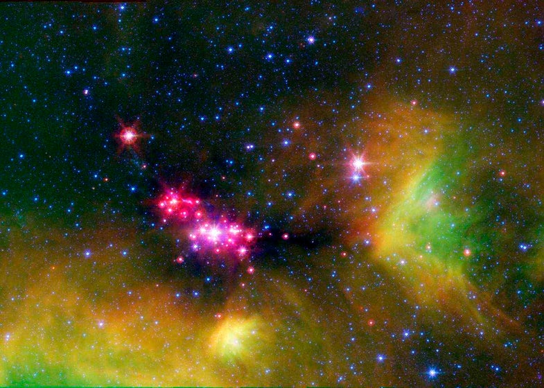 Infant stars are glowing gloriously in this infrared image of the Serpens star-forming region, captured by NASA's Spitzer Space Telescope.   The reddish-pink dots are baby stars deeply embedded in the cosmic cloud of gas and dust that collapsed to create it. A dusty disk of cosmic debris, or "protoplanetary disk," that may eventually form planets, surrounds the infant stars.   Wisps of green throughout the image indicate the presence of carbon rich molecules called, Polycyclic Aromatic Hydrocarbons (PAHs). On Earth, PAHs can be found on charred barbecue grills and in automobile exhaust. Blue specks sprinkled throughout the image are background stars in our Milky Way Galaxy.  The Serpens star-forming region is located approximately 848 light-years away in the Serpens constellation.  The image is a three-channel false-color composite, where emission at 4.5 microns is blue, emission at 8.0 microns is green, and 24 micron emission is red.