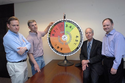 Ronald Prinn, director of MIT's Center for Global Change Science, and his group have revised their model that shows how much hotter the Earth's climate will get in this century without substantial policy change. Standing with the group's "roulette wheel" are, from left to right, Mort Webster, professor in the Engineering Systems Division; Adam Schlosser, principal research scientist at the Center for Global Change Science; Prinn, the TEPCO Professor of Atmospheric Chemistry; and Sergey Paltsev, principal research scientist, MIT Energy Initiative.