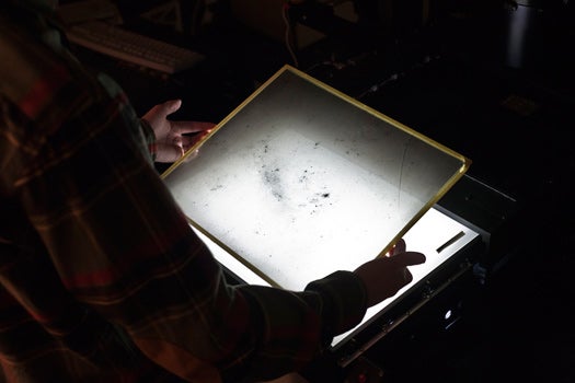 Curatorial Assistant David Sliski arranges a glass plate negative on the scanner's lightbox.