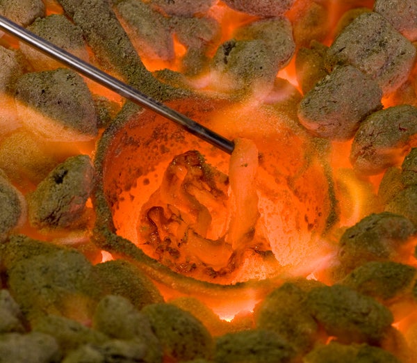 Sand mixed with ingredients over burning coals.