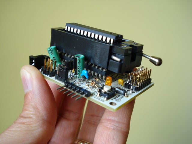 A person holding a circuit board.