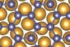 This illustration shows the arrangement of germanium atoms (purple) in germanene. The golden atoms in the background represent germanene's gold substrate.