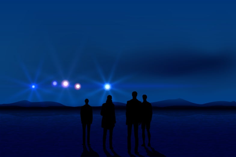 Group of men seeing UFO in the dark sky