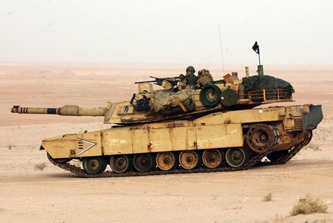 soldiers on the M1A2 Abrams battle tank in the desert