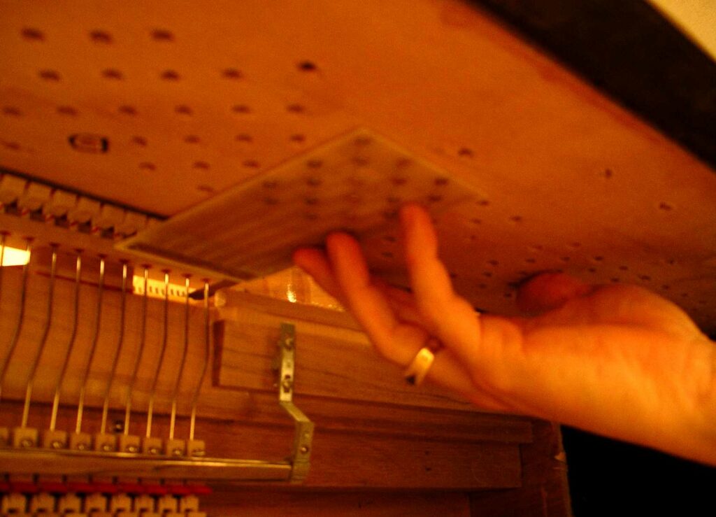 The springs are installed in the pinblock, which is typically made of hard wood and keeps the piano's tuning pins secured. The springs touch the tuning pegs through the pegs' pre-drilled holes.