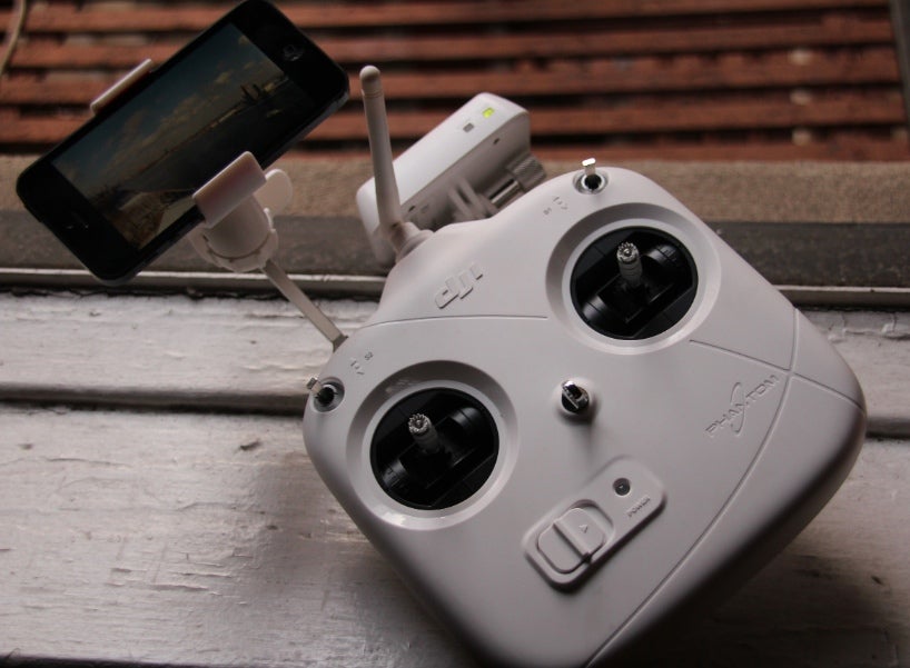 The aircraft is controlled via the familiar dual-thumbstick RC control scheme, while the camera is operated via a separate Wi-Fi connection with an app on the user's mobile device. The white box attached to the front of the controller is a small Wi-Fi signal booster.