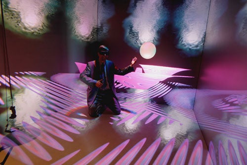 a man kneeling on the floor in a room full of disco lights