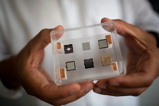 Paulo Lozano holds a case displaying the construction phases of small thruster made of silicon, gold, and porous metals that will be used in orbit on small satellites. Lozano is the Associate Director of the Space Propulsion Lab and an Associate Professor of Aeronautics and Astronautics at MIT in Cambridge, Massachusetts, USA. Lozano's current research focuses on the development of small thrusters for satellites. The thrusters his lab has developed are about the size of a single die cube and contain enough fuel to power the thrusters for a year in space. The thrusters will be used on small satellites.