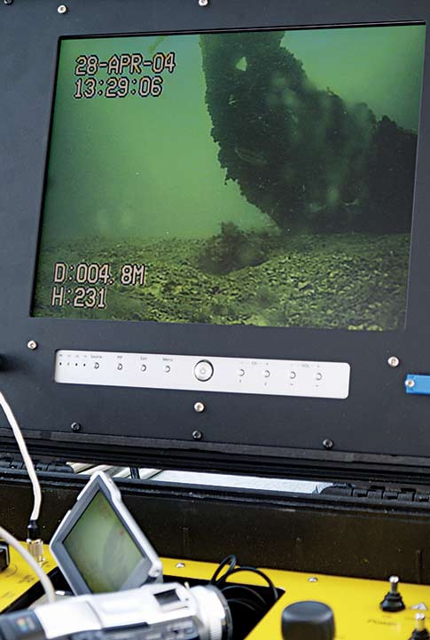 Real-time video is taken of a sunken lifeboat's bow from a remotely operated vehicle (ROV).
