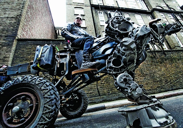 A man riding a vehicle that is half robot beast, half truck.