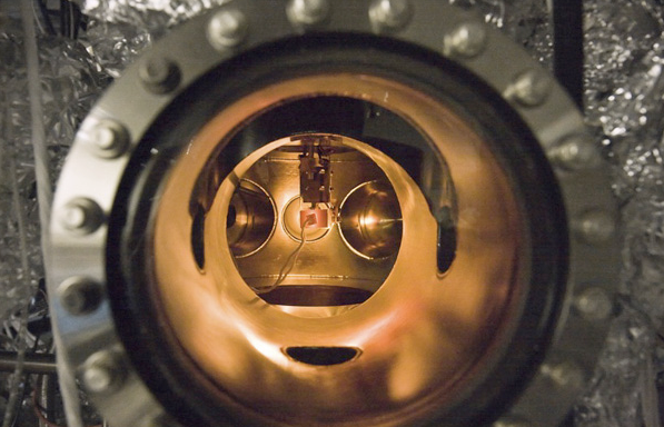 A small PETE device made with cesium-coated gallium nitride glows while being tested inside an ultra-high vacuum chamber. The tests proved that the process simultaneously converted light and heat energy into electrical current.