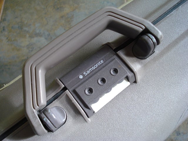 The handle of a black briefcase, with a combination lock built in.