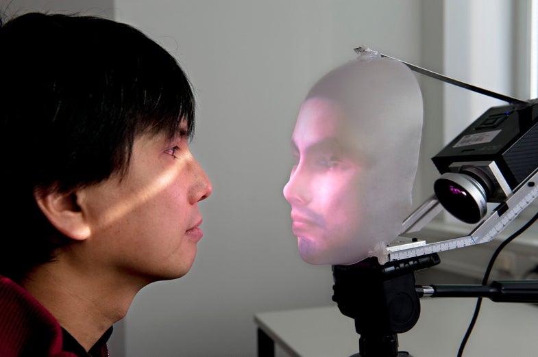 Dr. Takaaki Kuratate confronts his robot communication interface, Mask-Bot.