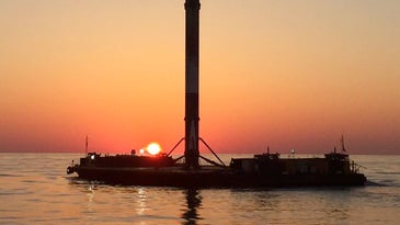 SpaceX drone ship with Falcon 9 rocket at sunset