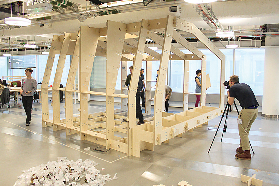 At WikiHouse’s London office space, visitors inspect the frame of a prototype shelter. The joints have wedge and peg connections inspired by classical Korean architecture.