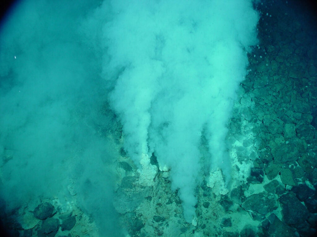 vents of white bubbles rising up from ocean floor