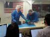 In a clean room, Bill Nye helps engineers prep LightSail 2 for testing.