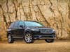 A Volvo XC90 with rugged rocks in the background