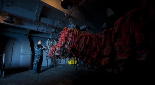 111008-N-TU221-298 PACIFIC OCEAN (Oct. 8, 2011) Boatswain’s Mate Seaman Preston Parr sorts float coats in a storage space aboard the Nimitz-class aircraft carrier USS Abraham Lincoln (CVN 72). Abraham Lincoln is underway conducting a composite training unit exercise. (U.S. Navy photo by Mass Communication Specialist 3rd Class Travis K. Mendoza/Released)