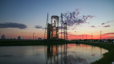 Delta IV Heavy on a launch pad with the sun setting in the background