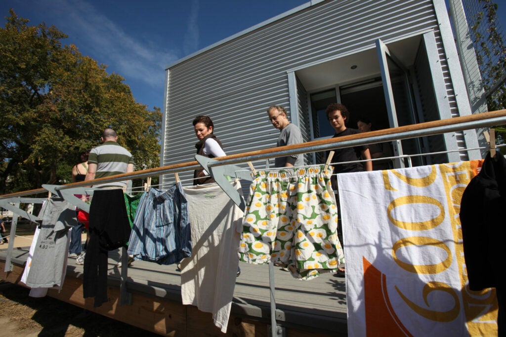 Decathletes were required to "live" in their homes, a contest designed to prove each house could offer all the amenities and comforts of a modern home despite its net-zero energy use. Teams took showers, washed laundry and hosted parties where they were required to cook for other teams. In this photo, Rice University students save energy by using the sun to do more than power their washing machines — it can be an efficient dryer, too.
