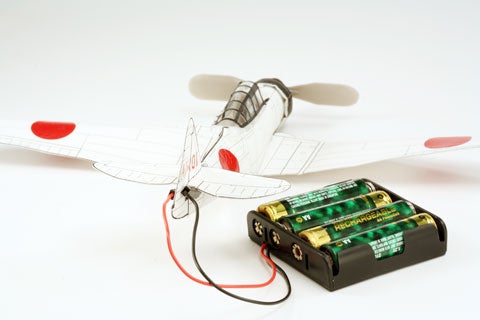 Installing batteries to run a paper plane motor.