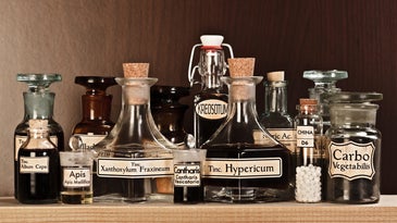 glass bottles on a shelf with handwritten labels
