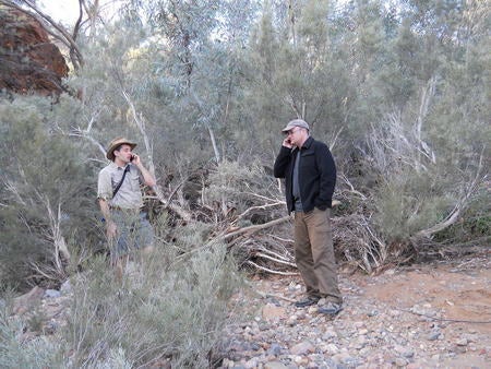 Paul Gardner-Stephen (left) talks with a colleague in the Australian Outback using his new Serval system, which turns any Wi-Fi enabled phone into a mesh network router.