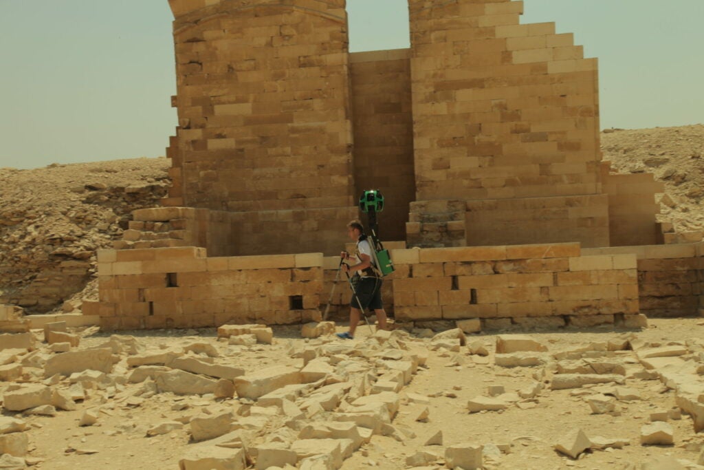 A technician carries Google Street View's "Trekker" camera among the monuments at Giza.