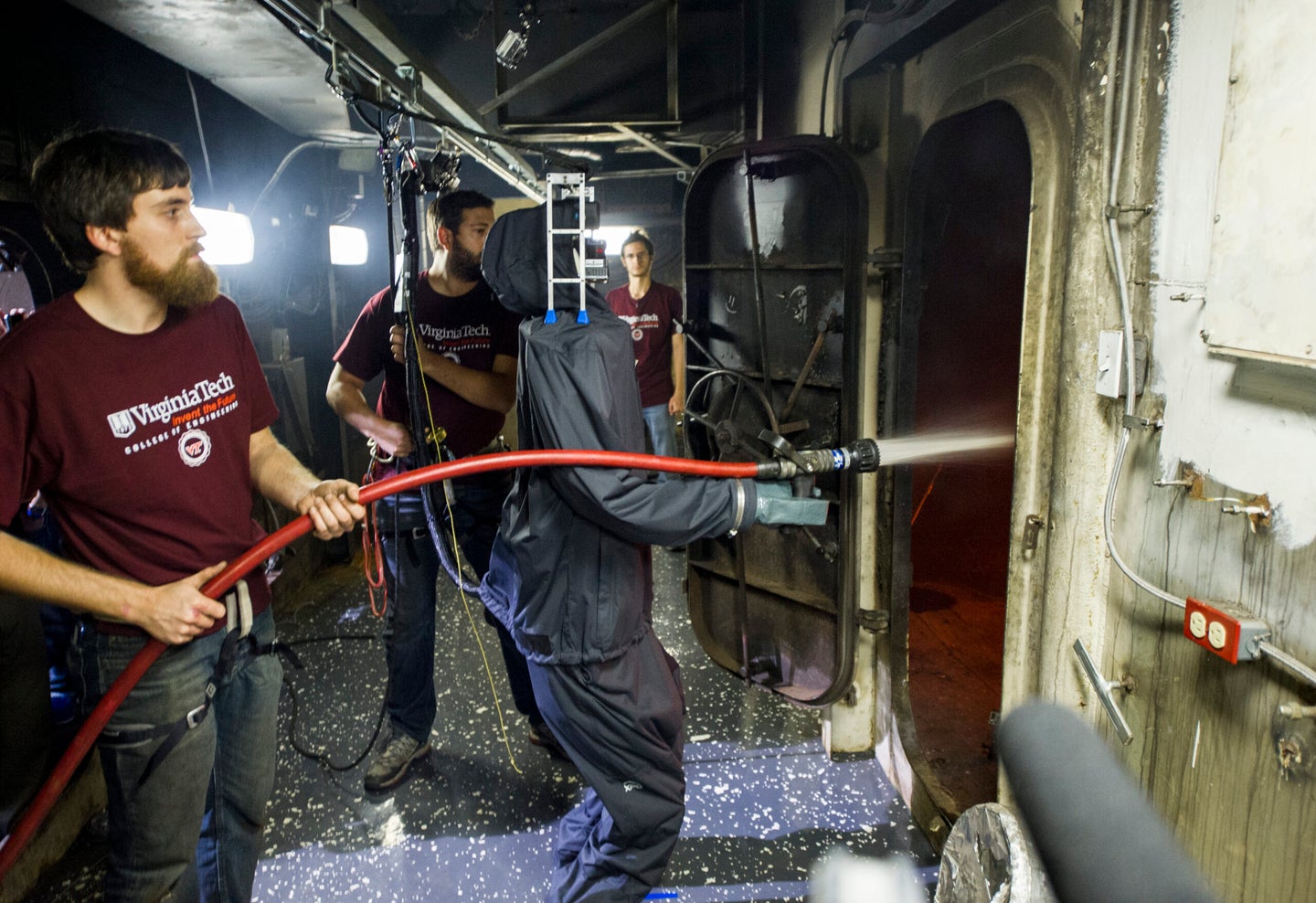 141106-N-PO203-059 MOBILE, Ala. (Nov. 6, 2014) Coleman Knabe, a graduate student at Virginia Tech, assists as the Office of Naval Research-sponsored Shipboard Autonomous Firefighting Robot (SAFFiR) extinguishes a fire during testing aboard the Naval Research Laboratory's ex-USS Shadwell located in Mobile, Alabama. SAFFiR is a bipedal humanoid robot being developed to assist Sailors with damage control and inspection operations aboard naval vessels. (U.S. Navy photo by John F. Williams/Released)