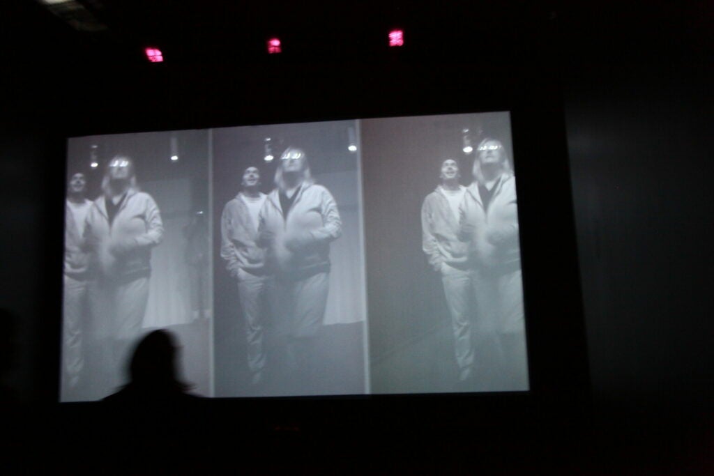 The number three unifies this room. There are three infrared cameras, three lamps, three video projectors and three computers that use light to present a ghostly likeness of viewers back to them. More specifically, the three cameras create a triptych, and one of the cameras is on a split-second delay, creating a slightly unreal version of the filmed user. After entering the dark room, some people hopped up and down, others waved their hands frantically, and others just stood there and laughed as they saw their image on screen. One teenage girl kept giggling with her friends, saying, "What are we supposed to do?" Another girl replied, "Jump!"