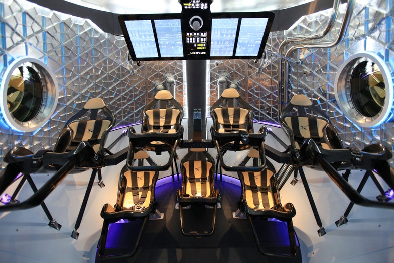 A look through the open hatch of SpaceX's Dragon V2 capsule, one of two designs chosen for NASA's Commercial Crew Transportation Capability program. Both Boeing and SpaceX have been told to halt production of their space taxi designs until a protest filed by the Sierra Nevada Corporation has been resolved.