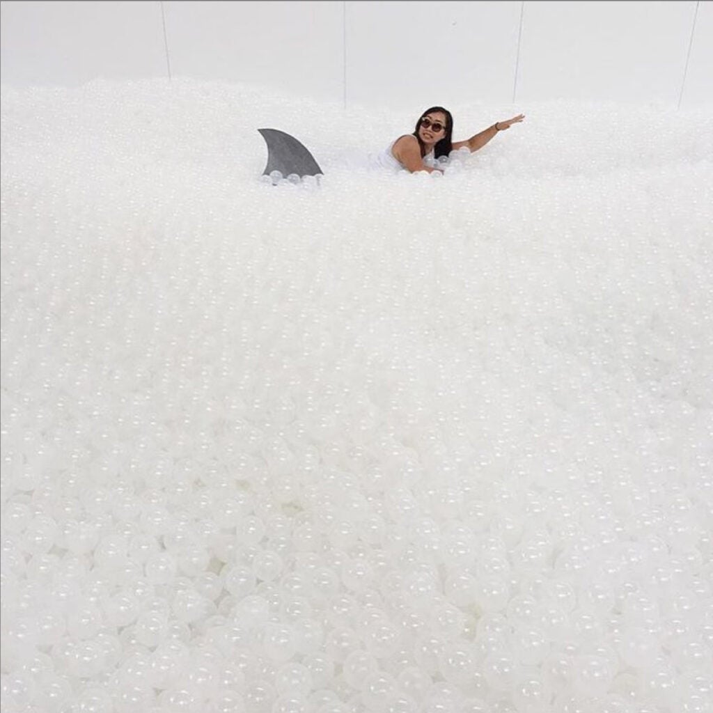 Snarkitecture, a Brooklyn-based architecture studio, has transformed an area of National Building Museum in Washinton D.C. into a 10,000 square-foot faux indoor beach. The team used astroturf and around 1 million translucent plastic balls to mimic the ocean, as well as white deck chairs and umbrellas to replicate the feeling of going to the beach. For 16 dollars, visitors can lounge around the “beach” or wade through the sea of recyclable balls without having to worry about embarrassing tan lines.