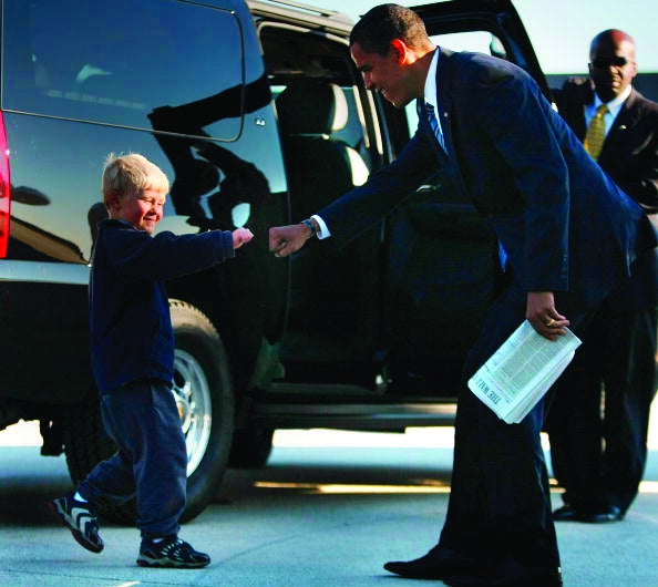 CHANTILLY, VA- OCTOBER 22: Democratic presidential nominee U.S. Sen. Barack Obama (D-IL) fists bumps with Ethan Gibbs the son of Robert Gibbs the campaign communication director as he arrives at Dulles International Airport October 22, 2008 in Chantilly, Virginia. Obama continues to campaign with election day less than two weeks away. (Photo by Joe Raedle/Getty Images)
