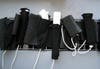 Several Wii Remotes in a black Wiimote holster.