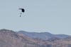 alone paraglider flying over a mountainous area