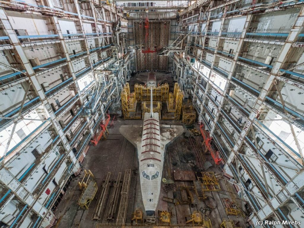 The unflown orbiter Ptichka and a full scale mockup intended for structural testing purposes sit in a hangar, rotting.